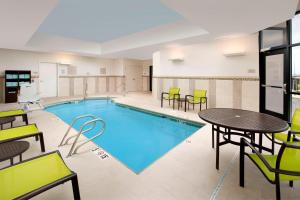 阿拉米达SpringHill Suites by Marriott Albuquerque North/Journal Center的酒店客房的游泳池配有桌椅