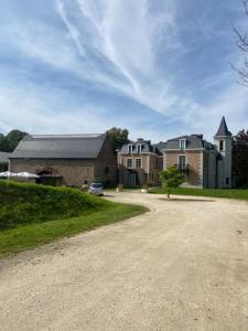 列日La chambre et le studio du château du golf de Bernalmont的车道上停放着一辆汽车的大型砖砌建筑