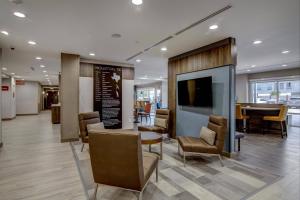 休斯顿TownePlace Suites by Marriott Houston Hobby Airport的一个带椅子和桌子的大堂以及一间用餐室