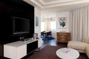 阿可贺巴艾美度假酒店的客厅配有电视、沙发和桌子
