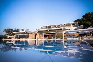 卡塔海滩Kata Rocks - SHA Extra Plus的一个带椅子的游泳池和一座建筑的度假胜地