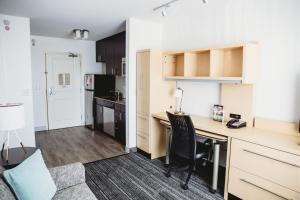 Melrose AdditionTownePlace Suites by Marriott Aberdeen的公寓内设有厨房和带书桌的客厅。