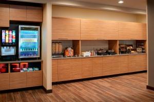 大急流城TownePlace Suites by Marriott Grand Rapids Airport的厨房配有木制橱柜和冰箱。