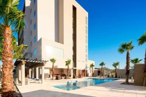 埃莫西约埃莫西万豪万怡酒店的一座拥有游泳池和棕榈树的酒店
