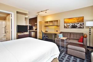 法明代尔长岛法明戴尔利帕布力克机场广场套房酒店的酒店客房,配有床和沙发