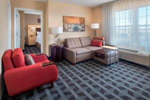 法明代尔长岛法明戴尔利帕布力克机场广场套房酒店的带沙发的客厅和带沙发床的房间