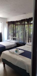 阿卡普尔科Casa Costa Brava的一间卧室设有三张床和窗户。