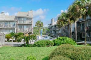 圣乔治岛Ocean Mile L7 Gulf Beach Getaway的一排棕榈树和草的公寓楼