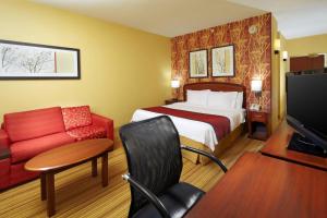 阿尔图纳阿尔图纳万怡酒店的酒店客房,配有一张床和一张红色的沙发