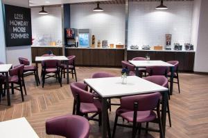 达文波特Fairfield Inn & Suites by Marriott Davenport Quad Cities的一间带桌子和紫色椅子的用餐室