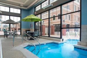 霍兰霍兰市中心万怡酒店的大楼内带遮阳伞的游泳池