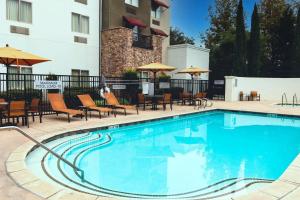 佩索罗伯斯帕索罗布莱斯万怡酒店的游泳池,酒店配有椅子和遮阳伞