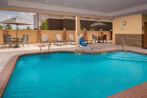 梅泰里Fairfield Inn & Suites by Marriott New Orleans Metairie的酒店的大型游泳池配有桌椅