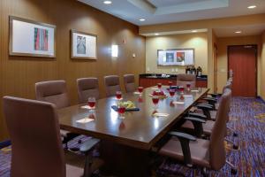 法明代尔长岛/法明代尔共和国机场万怡酒店的一间会议室,配有长木桌子和椅子