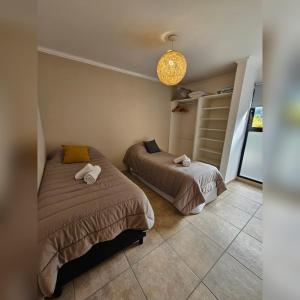 埃博森Andes Departamentos的一间卧室配有两张床和吊灯。