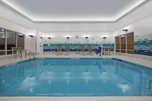 伍德布里奇TownePlace Suites by Marriott Potomac Mills Woodbridge的大楼内的一个蓝色海水游泳池