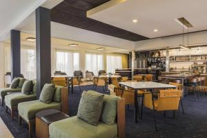 土桑图森机场万怡酒店的酒店大堂设有桌椅和餐厅