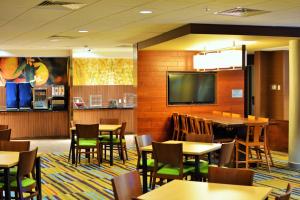 奥马哈奥马哈西北万豪费尔菲尔德酒店的用餐室配有桌椅和平面电视。