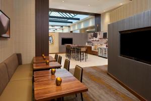 达拉姆达勒姆市中心万豪酒店的餐厅设有2张桌子和平面电视