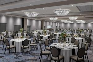 威斯敏斯特Delta Hotels by Marriott Denver Thornton的宴会厅配有桌椅和吊灯