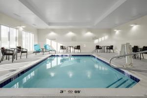IrontonTownePlace Suites by Marriott Ironton的一座配有桌椅的酒店游泳池