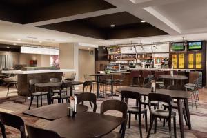 托皮卡托皮卡万怡酒店的一间带桌椅的餐厅和一间酒吧