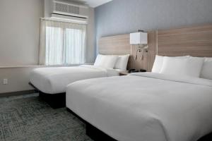 布鲁克林TownePlace Suites by Marriott New York Brooklyn的酒店客房设有两张床和窗户。