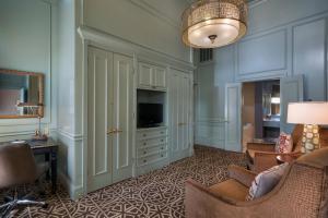 休斯顿阿尔冈昆签名典藏酒店的客厅配有电视、沙发和椅子