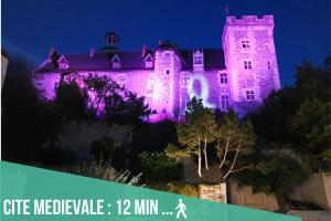 蒙吕松Artbleu -Tout Confort - Idéal Pros - Proche commerces的一座城堡,晚上点燃紫色的灯光