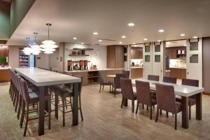 西乔丹Residence Inn by Marriott Salt Lake City-West Jordan的厨房以及带桌椅的用餐室。