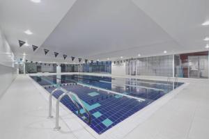 特威克纳姆London Twickenham Stadium Hotel, a member of Radisson Individuals的大楼内一个蓝色瓷砖的大型游泳池