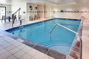 朗康科马长岛麦克阿瑟机场万怡酒店的一座配有桌椅的酒店游泳池