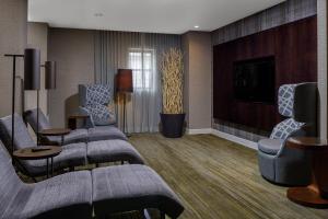 朗康科马长岛麦克阿瑟机场万怡酒店的酒店客房设有沙发、电视和客厅。