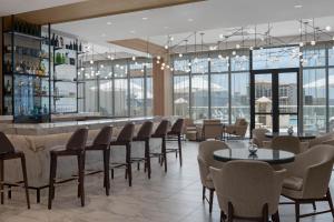 克利尔沃特AC Hotel by Marriott Clearwater Beach的一间带桌椅的餐厅和一间酒吧
