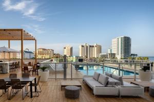 克利尔沃特AC Hotel by Marriott Clearwater Beach的屋顶庭院配有沙发和桌椅