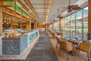 茂名茂名喜来登温泉度假酒店的餐厅设有桌椅和窗户。