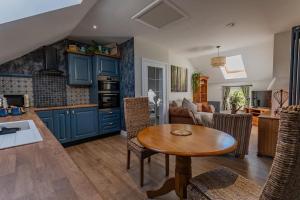 CranwellLuxury retreat in Lincolnshire with hot tub的厨房配有蓝色橱柜和木桌