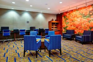 凤凰城凤凰城北/欢乐谷万怡酒店的一间会议室,配有蓝色椅子和绘画作品