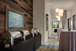 奥欣赛德万豪圣地亚哥欧申赛德/市中心春季山丘套房酒店的餐厅设有桌子,墙上挂有绘画作品