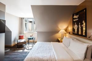 慕尼黑慕尼黑艾美酒店的配有一张床和一把椅子的酒店客房