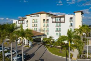 埃斯特罗SpringHill Suites by Marriott Fort Myers Estero的前面有棕榈树的酒店