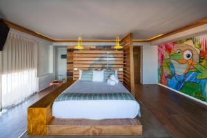 坎昆Mayan Monkey Cancun的卧室配有一张床,墙上挂有绘画作品