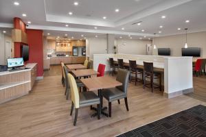 舍伍德帕克TownePlace Suites by Marriott Edmonton Sherwood Park的一间带桌椅的餐厅和一间厨房