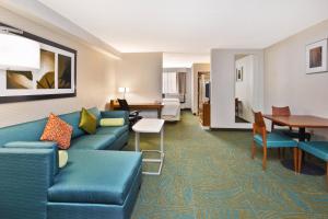 布尔里奇SpringHill Suites by Marriott Chicago Southwest at Burr Ridge Hinsdale的酒店客房配有蓝色的沙发和桌子