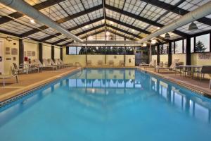 布尔里奇SpringHill Suites by Marriott Chicago Southwest at Burr Ridge Hinsdale的大楼内带桌椅的大型游泳池
