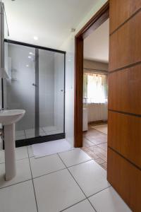 里约达斯弗洛雷斯Kings International Hotel的一间带玻璃淋浴和水槽的浴室