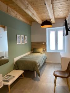帕尔马诺瓦Palmamore的一间卧室配有一张床、一张桌子和一个窗户。