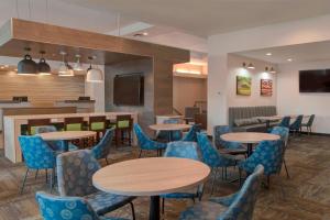 斯波坎谷Fairfield Inn & Suites by Marriott Spokane Valley的一间配备有桌子和蓝色椅子的用餐室