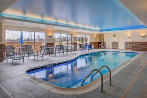 马里兰高地Fairfield Inn & Suites by Marriott St. Louis Westport的一座配有桌椅的酒店游泳池