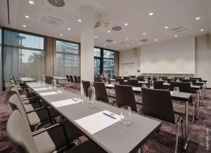 嘉兴贝慕尼黑Dorint Hotel München/Garching的一间会议室,配有桌椅和白板